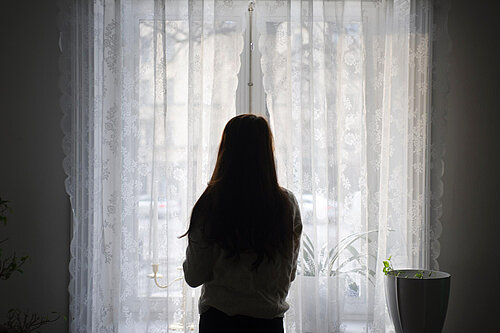 A woman looking out a window.