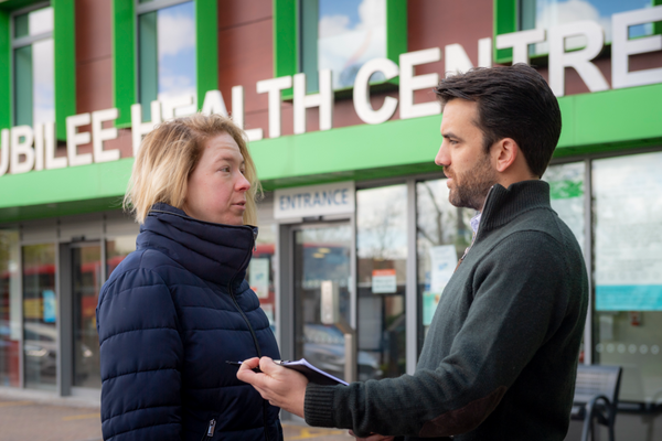 Bobby outside a health centre with a resident