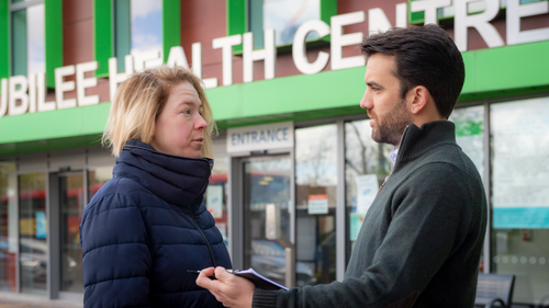 Bobby speaking to resident outside GP surgery